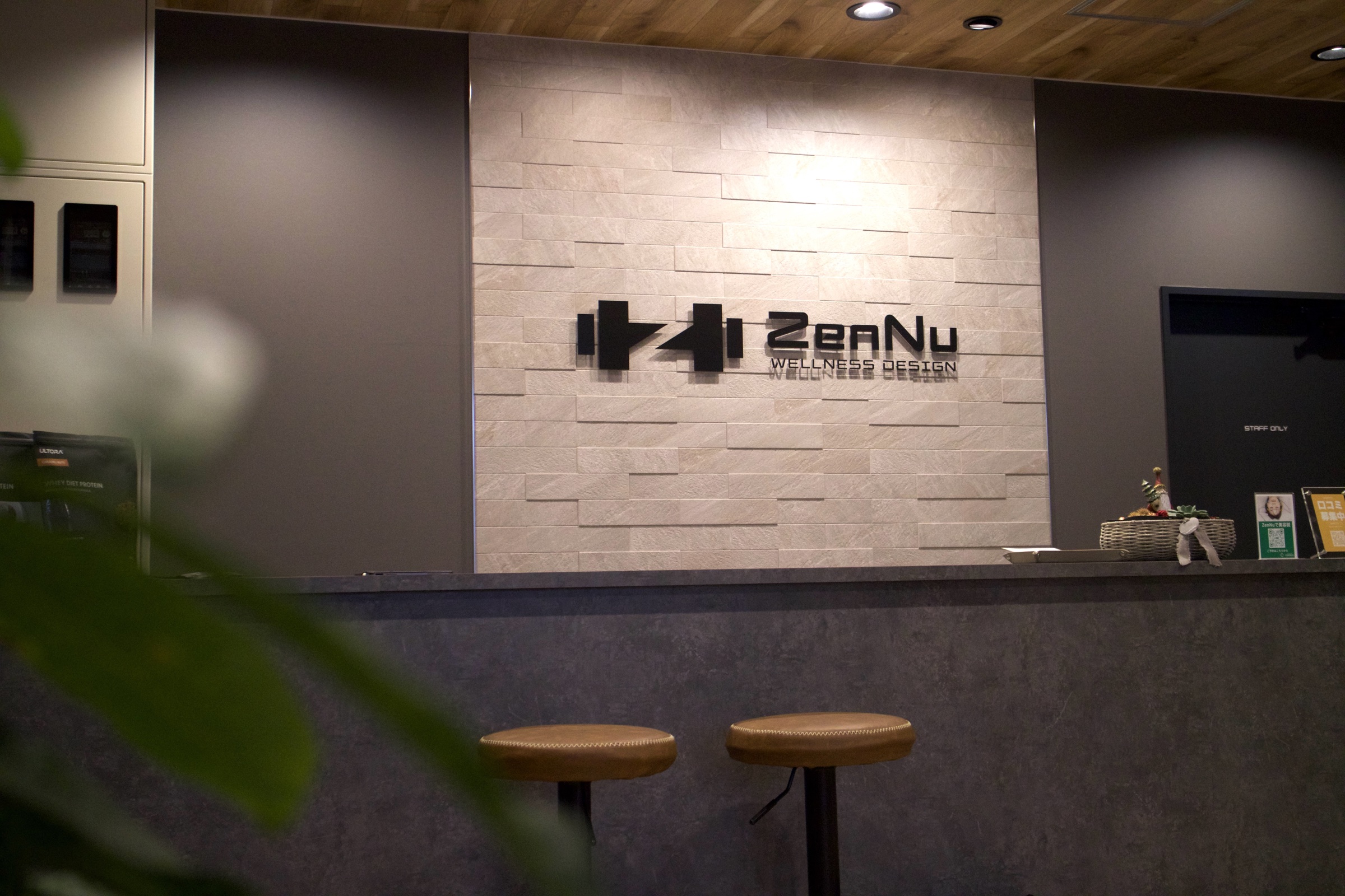 熊本・上通のZenNu WELLNESS DESIGN受付カウンターとロゴウォール